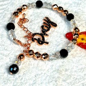 Rose gold bracelet with dangle charm that says PRAY